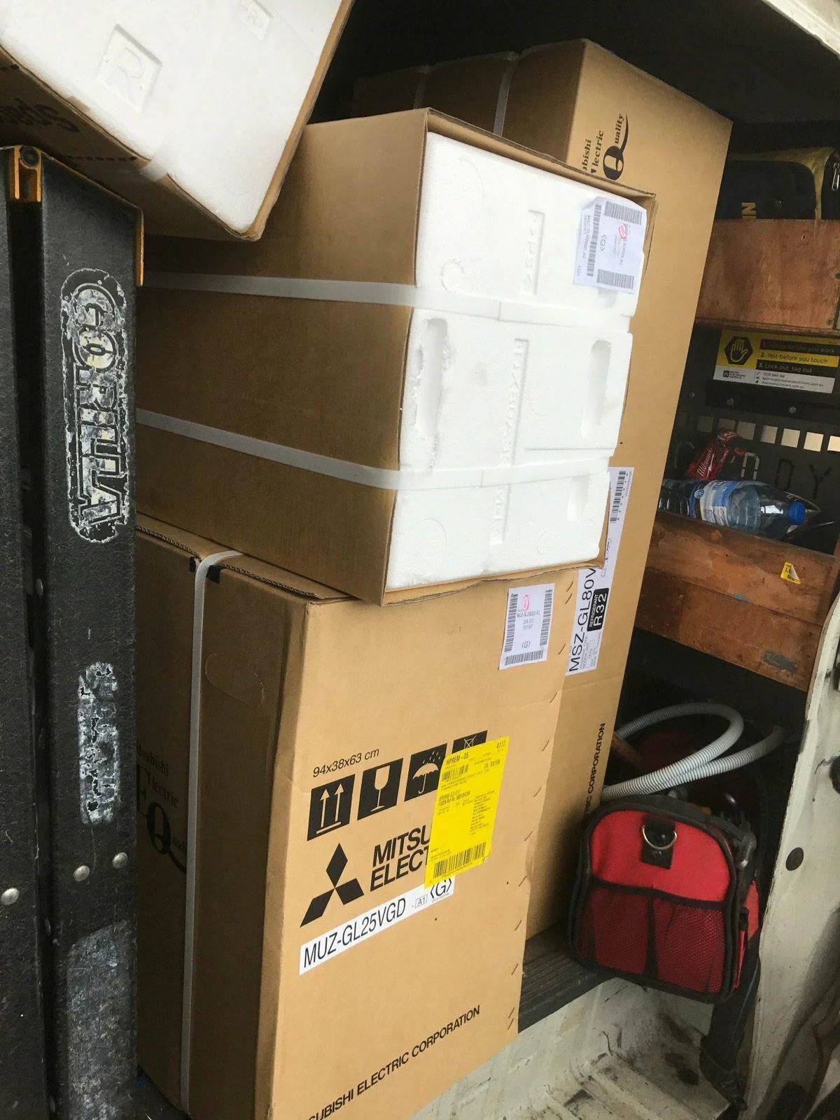 Boxed Mitsubishi Electric air conditioning units loaded in the work van, ready for install