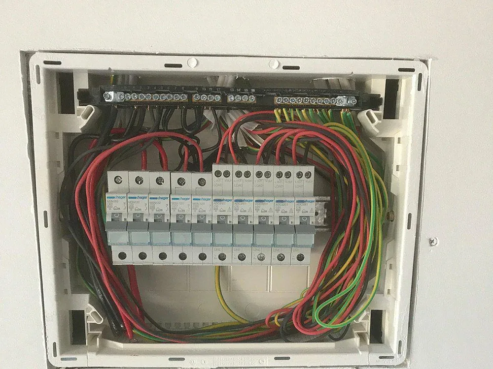 New switchboard with a row of safety switches and neatly dressed red, black and green wiring